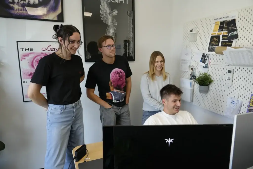 Milena Birkel und das Team schauen gemeinsam auf einen Bildschirm