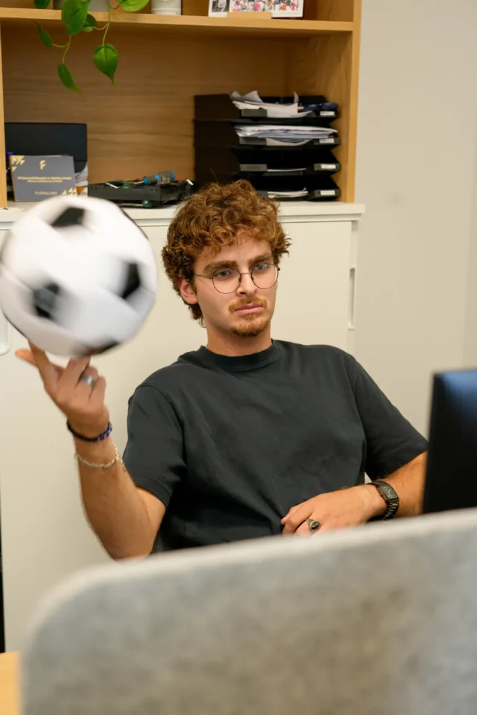 Hsham balanciert einen Fußball am Arbeitsplatz